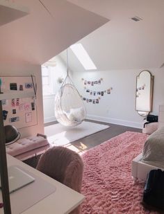 a bedroom with pink rugs and hanging hammock chair in the middle of the room