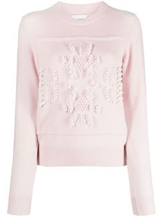 a pink sweater with white flowers on it