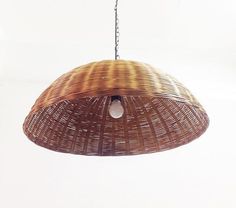 a brown wicker light hanging from a chain