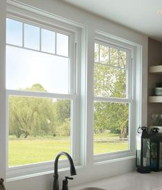 a kitchen sink sitting under two large windows