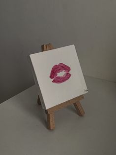 a small easel with a red lipstick imprint on it