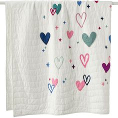 a white quilt with hearts and stars on it