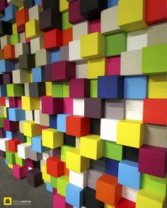 a colorful wall made up of squares and rectangles in different colors on the wall