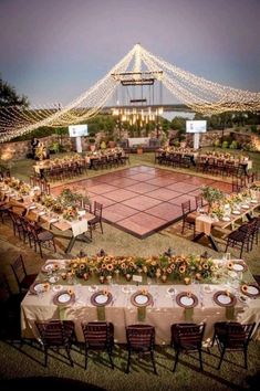 an outdoor tennis court is set up with tables and chairs for dinner guests to enjoy