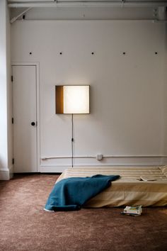 a room with a bed and a lamp on the wall