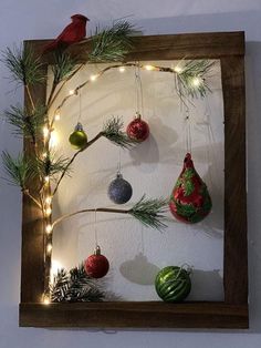 a wooden frame with ornaments hanging from it's sides and lights on the side