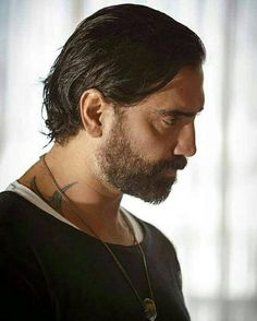 a man with long hair and a beard wearing a black shirt