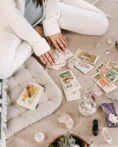 a woman sitting on the floor surrounded by cards