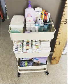 a white cart filled with lots of diapers next to a measuring tape and toiletries