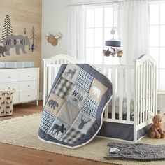 a baby crib with a teddy bear quilt on it