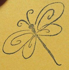 a drawing of a dragonfly is shown on a piece of yellow paper with black ink