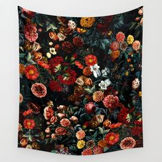 a tapestry hanging on the wall with flowers all over it's surface and leaves