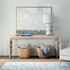 two wicker baskets sit under a painting on the wall next to a white couch