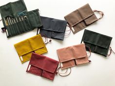 five different colored purses sitting next to each other on top of a white surface