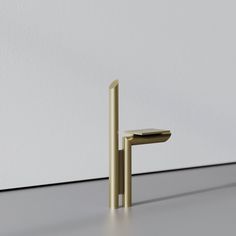 a gold faucet sitting on top of a white floor next to a wall