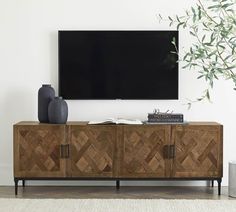 an entertainment center with a large flat screen tv mounted on it's sideboard