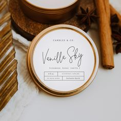 candles and cinnamon sticks on a table with vanilla sky logo in the center, surrounded by other items