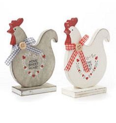 two wooden rooster figurines with red and white bows