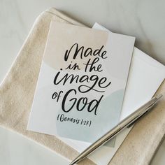 a note with the words made in the image of god on it next to a pen and envelope