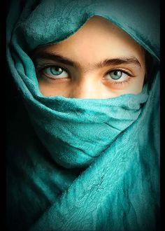 a woman with blue eyes wearing a green scarf