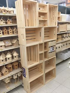 wooden birdhouses are stacked on shelves in a store