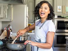 a woman in an apron is cooking on the stove with a ladle and smiling