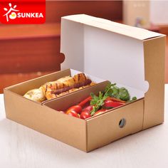 an open box with some food inside of it on a white counter top next to a wooden table