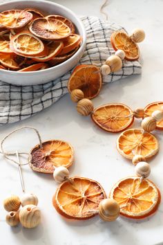 dried orange slices and shells on a towel next to a bowl of garlic cloves