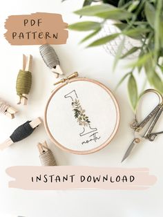 a cross stitch pattern with scissors and other crafting supplies on the table next to it