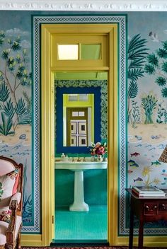 an open door leading to a bathroom with blue and yellow wallpaper