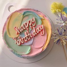 a birthday cake with the words happy birthday written on it and flowers next to it