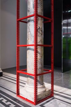 a red and white column sitting in the middle of a room