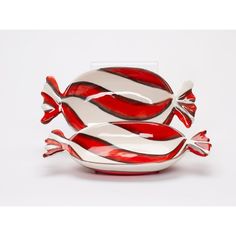 red and white striped glass bowl with two fish on the bottom, sitting in front of a