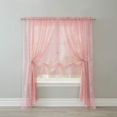 a pink curtain hanging on the side of a window