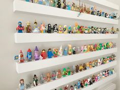 there are many toy figurines on the shelves in this room, all lined up