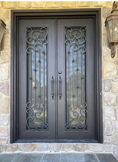 a pair of double doors with decorative iron work on the front door and sidelights