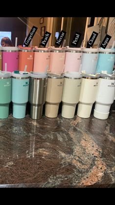 many different colored cups are lined up on the counter