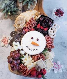 a snowman made out of food on top of a cutting board next to some berries