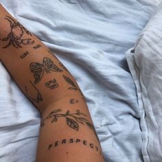 a person laying in bed with tattoos on their arm