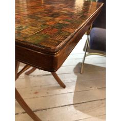 a wooden table sitting on top of a hard wood floor next to a blue chair