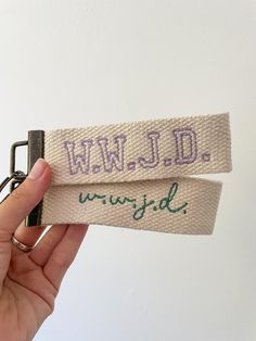 someone is holding up two key chains that say wwjldd and wrigid