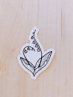 a sticker with a flower on it sitting on top of a piece of wood