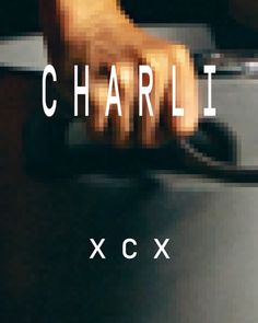 a blurry image of a person's hand on top of a table with the words charlie xcx