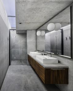 a bathroom with two sinks and mirrors on the wall next to a walk in shower