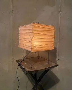 a lamp sitting on top of a wooden table next to a light bulb in the shape of a rectangle