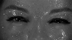 black and white photograph of woman's face with glitter on her skin, close up