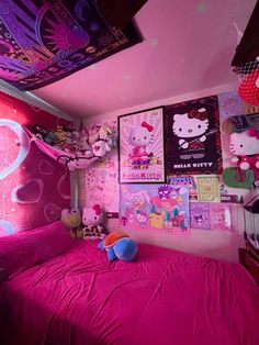 a bedroom decorated in pink and purple with hello kitty pictures on the wall above the bed