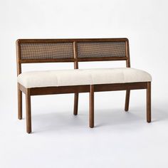 a bench made out of wood and wicker sitting on top of a white floor