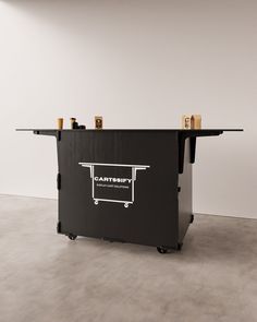 a black table with two bottles on top and a cart in the middle that says cartish