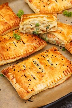 several pastries sitting on top of a pan covered in cheese and meat toppings